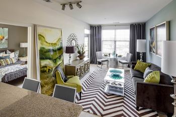 a living room with a couch and chairs at Reveal Hackensack apartments